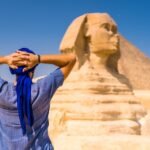 young-tourist-wearing-blue-turban-standing-near-great-sphinx-giza-cairo-egypt_181624-46822